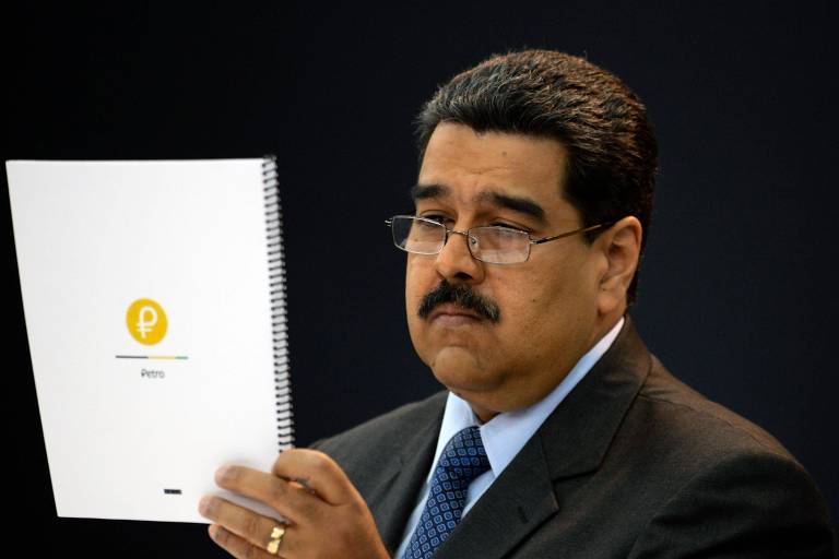 O ditador da Venezuela, Nicolás Maduro, lê documento durante reunião sobre o petro, a moeda virtual do país, no dia 20