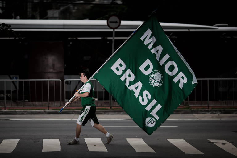 O empresário e torcedor palmeirense Anderson Rodrigues passeia pelas ruas com bandeira em alusão ao Palmeiras