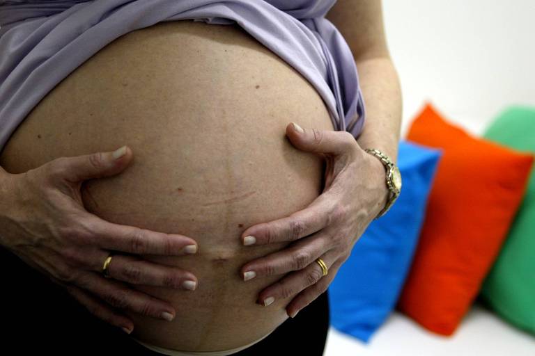 Com as mãos na barriga, grávida de São Paulo, que espera casal de gêmeos 
