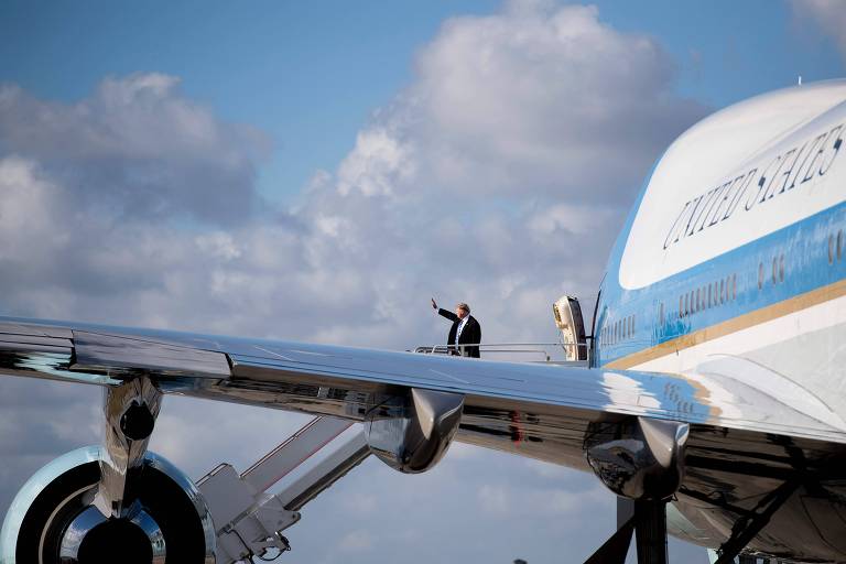 O presidente americano Donald Trump acena antes de embarcar no Air Force One na Flórida 