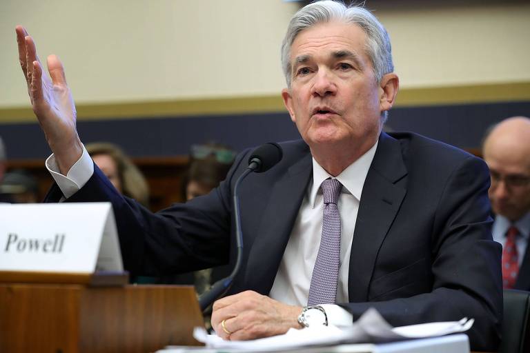 O presidente do banco central norte-americano, Jerome Powell, ergue os braços