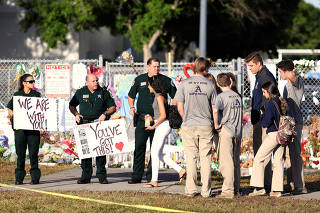 Police and law enforcement officers show their support as students arrive at Marjory Stoneman Douglas High School in Parkland