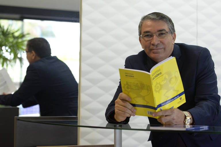 Homem de terno lê livro de capa amarela