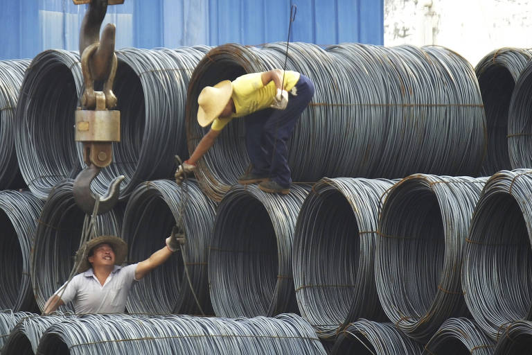 Funcionários do mercado de aço de Yichiang, na região central da China, preparam bobinas para transporte