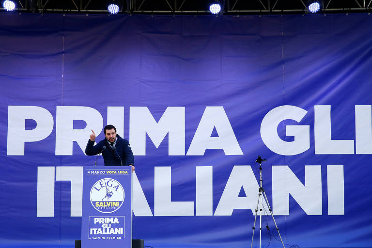 O líder da Liga, Matteo Salvini, discursa a militantes de seu partido em Milão; ao fundo, o lema de campanha: "Os italianos primeiro"