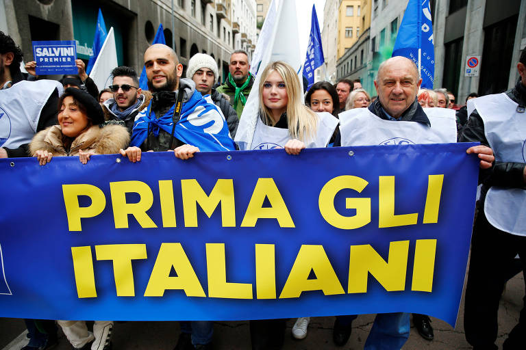 Apoiadores da Liga seguram faixa que diz "primeiro os italianos" em ato em Milão, Itália