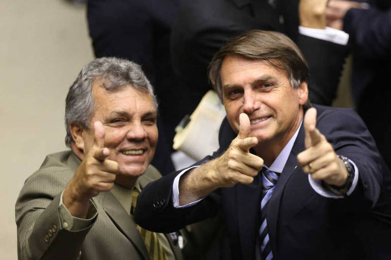  Alberto Fraga e Jair Bolsonaro fazem sinal com as mãos imitando armas de fogo durante a votação em segundo turno do projeto que muda a maioridade penal