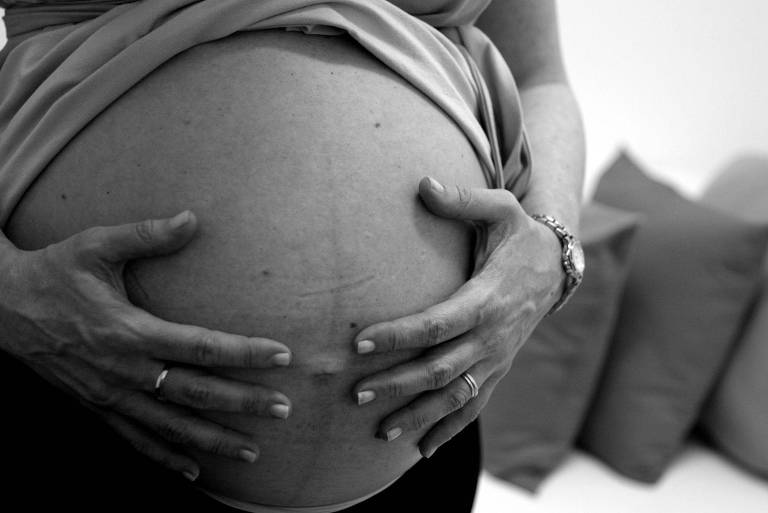 Futura mãe acaricia barriga de grávida