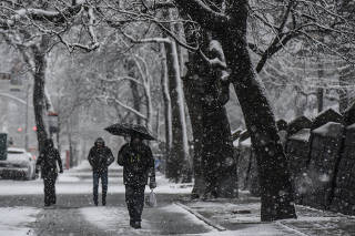 People walk through the snow during a storm in the Brooklyn borough of New York City