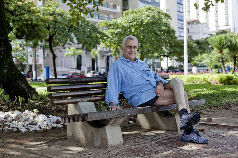 Orlando Lovecchio Filho, 66, na orla da praia de Santos; ele teve que amputar a sua perna após ter sido ferido com a explosão de uma bomba na ditadura militar