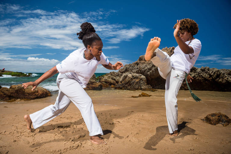 Priscila dos Santos pratica capoeira na praia, com uma colega, antes de exibição em Salvador, na semana passada