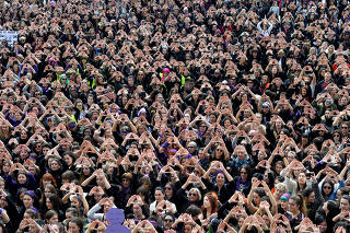 Protesters form triangles with their hands during a demonstration for women's rights in Bilbao