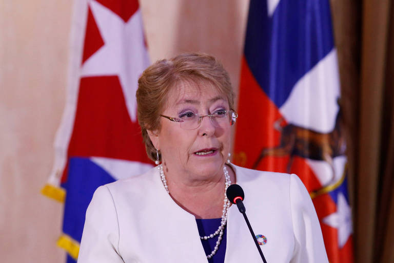 A presidente do Chile, Michelle Bachelet, discursando, com as bandeiras do Chile e Cuba ao fundo