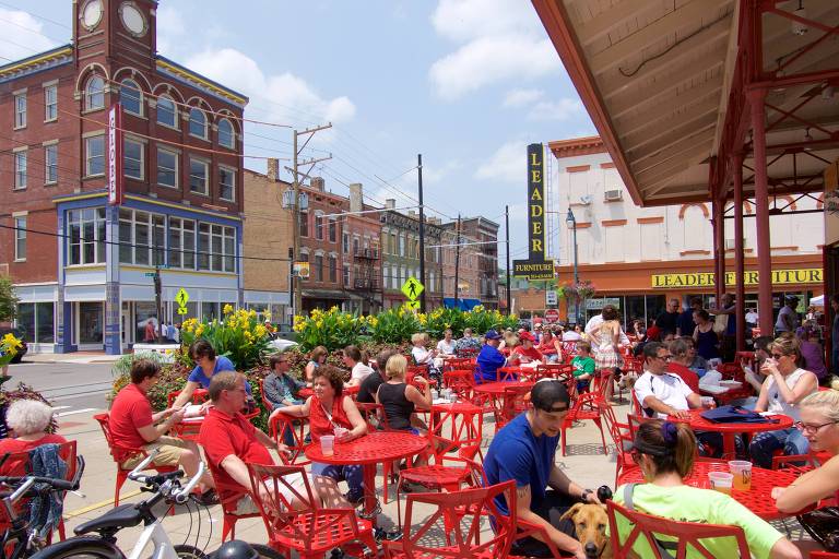 Turistas e moradores sentam em mesas do lado de fora do Findlay Market, uma das atrações de Cincinnati, em Ohio