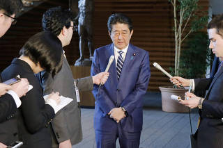 Japanese Prime Minister Shinzo Abe talks to reporters at his office in Tokyo