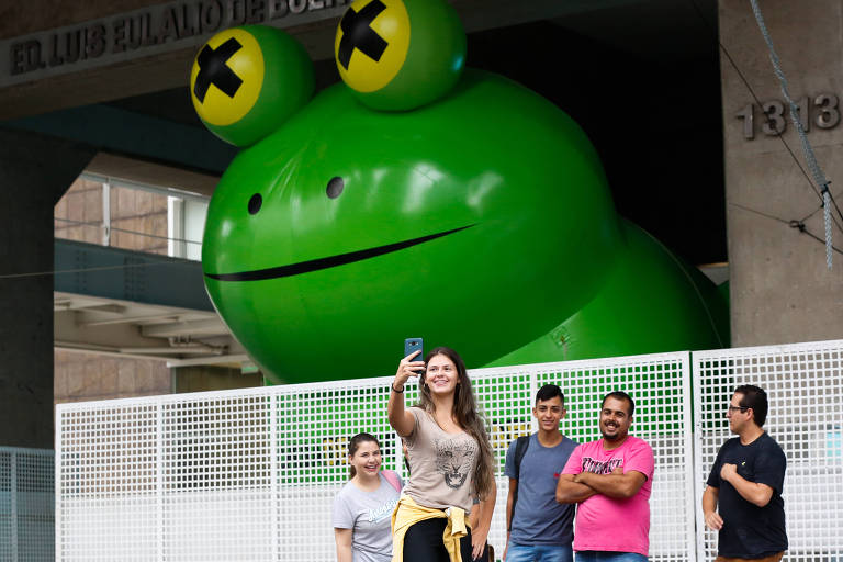 Pedestres fazem selfie com o sapo inflável da Fiesp atrás