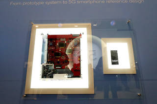 A display in the booth of Qualcomm shows the journey early 5G phone chipsets have made the Mobile World Congress in Barcelona.
