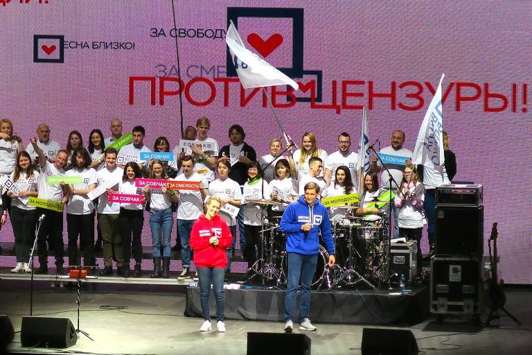 A candidata Ksenia Sobchak, em vermelho, e seu novo aliado, Dmitri Gudkov, em azul, no evento final da campanha