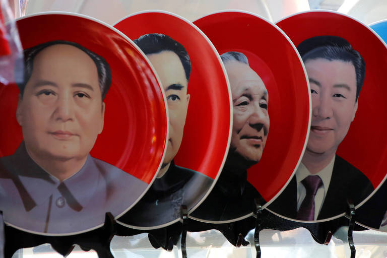 Pratos de fundo vermelho com os líderes Mao Tse-tung, Zhou Enlai, Deng Xiapoing e Xi Jinping são exibidos em estande de souvenires na praça da Paz Celestial, em Pequim