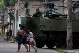 Armed forces members patrol during an operation against drug dealers in Vila Kennedy slum in Rio de Janeiro