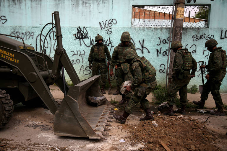 An armed forces members remove barricades during an operation against drug dealers in Vila Kennedy slum in Rio de Janeiro