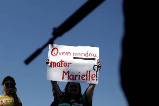 A demonstrator holds a banner which reads 