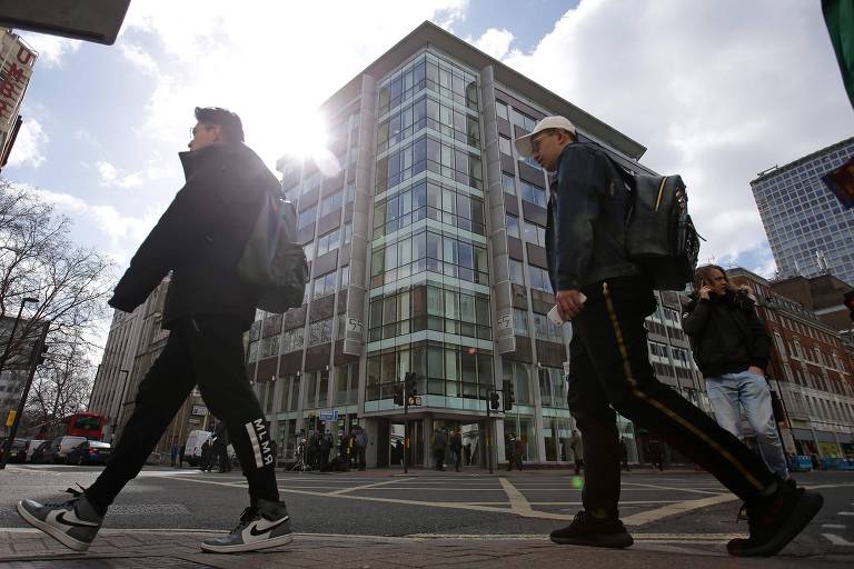 Pedestres caminham por edifício da Cambridge Analytica no centro de Londres