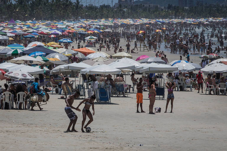 Banhistas aproveitam dia de sol na praia de Enseada, no Guarujá, litoral sul de São Paulo