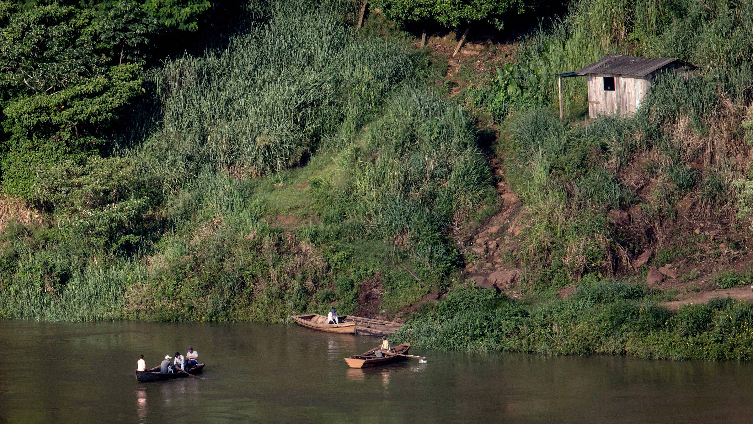 Barcos cruzam pelo rio Paraná a fronteira entre o Paraguai, no lado de cima da foto, e o Brasil, no lado de baixo (Bruno Santos/Folhapress)