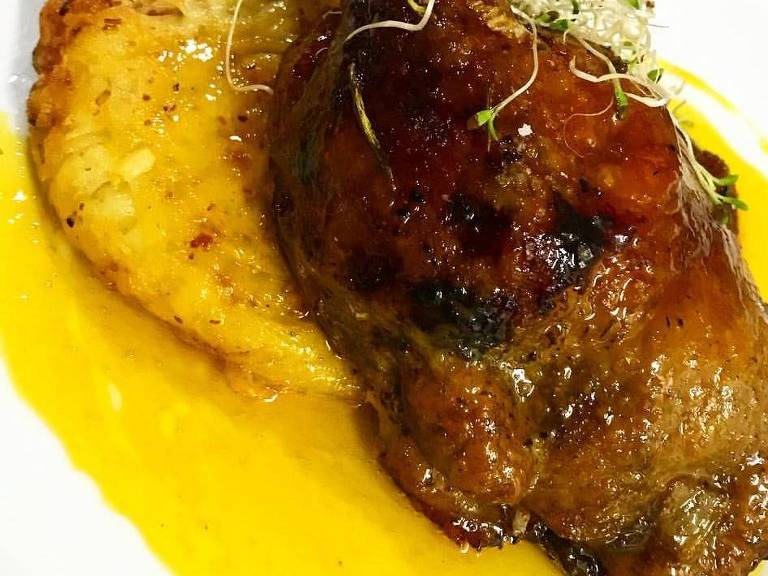 Confit de pato servido no restaurante Marcel, com casquinha crocante e molho de laranja