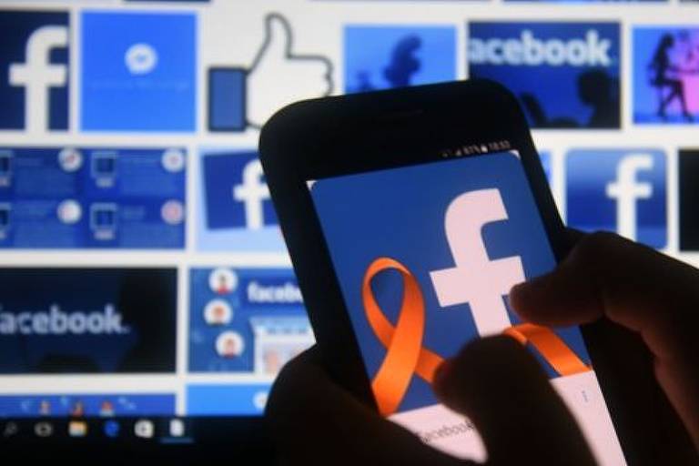 Usuário de rede social faz login no Facebook pelo telefone celular