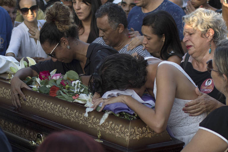 Familiares e amigos choram sobre caixão no enterro da vereadora Marielle Franco, assassinada no Rio de Janeiro aos 38 anos