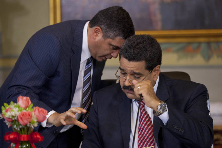 Em foto de 15 de outubro de 2014, o então ministro da Justiça Miguel Rodríguez Torres, fala com o presidente Nicolás Maduro no palácio presidencial Miraflores, em Caracas, na Venezuela. 