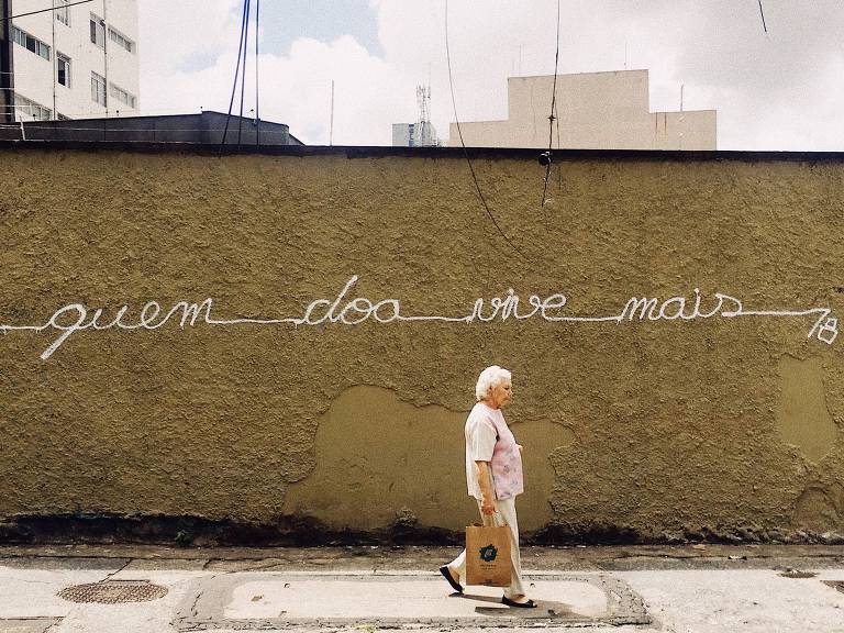 Grafite 'quem doa vive mais', feito em muro da rua Baronesa de Itu, região central de São Paulo, por Pedro Frazão, 38, que espalha mensagens incentivando a doação por São Paulo para ajudar organizações sociais