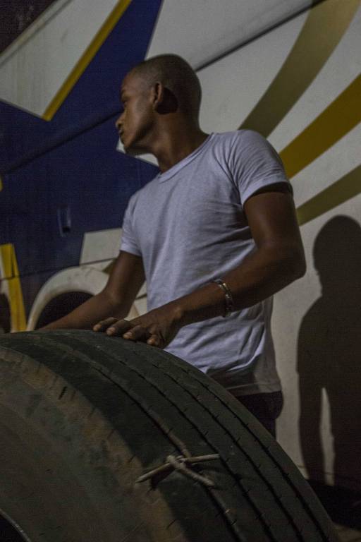 Homem mostra pneu furado por ganchos de metal pontiagudos lançados na estrada por opositores do ex-presidente Lula