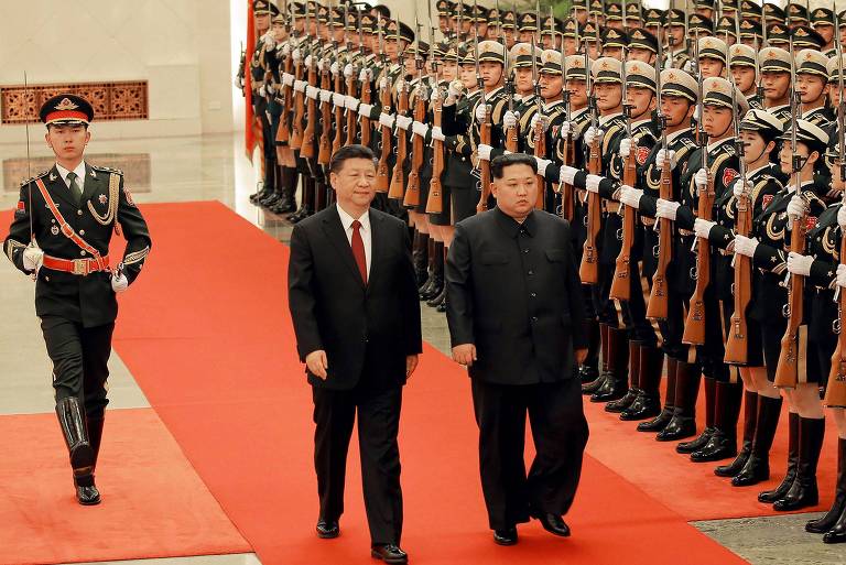 O chinês Xi Jinping (esq.) e o norte-coreano Kim Jong-un passam em revista às tropas em Pequim