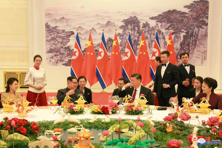 Reunião em Pequim entre Xi Jinping (sentado, de gravata vermelha), sua mulher Peng Liyuan (dir.), o norte-coreano Kim Jong-un e sua mulher Ri Sol-ju