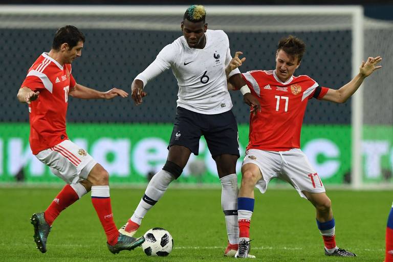 O meia francês Paul Pogba disputa bola com jogadores russos durante amistoso disputado em São Petersburgo 