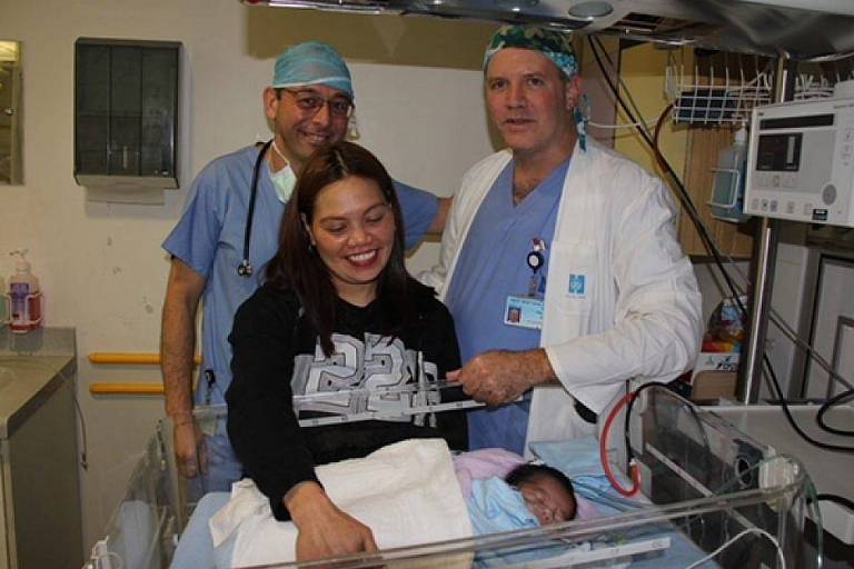 Médicos Julius Golender, e Sagi Gravi com a mãe filipina Nina e o bebê Francis Joseph, que nasceu com uma má-formação cardíaca