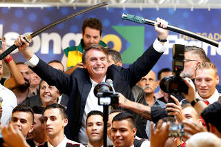 Federal deputy Jair Bolsonaro, a pre-candidate for Brazil's presidential elections, shows a sword during a rally in Curitiba