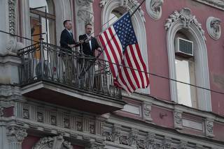 Employees take down the U.S. flag on the U.S. Consulate General in St. Petersburg
