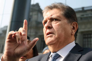 Former Peruvian president Alan Garcia talks to the media as he arrives at the National Prosecution office in Lima