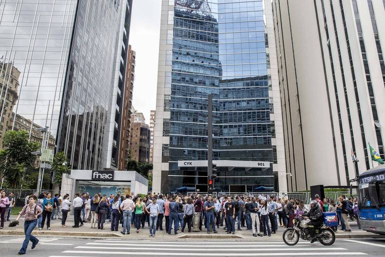 Foto mostra pessoas na calçada de prédio na avenida Paulista que foi evacuado após tremor