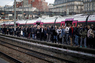 Commuters arrive at Saint-Lazare train station during a nationwide strike by French SNCF railway workers in Paris