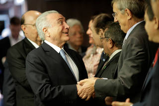 Brazil's President Michel Temer gestures beforea ceremony of joining of Brazil's Finance Minister Henrique Meirelles to the Brazilian Democratic Movement (MDB) party, in Brasilia