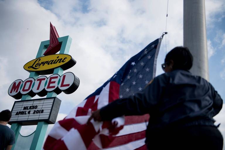 Mulher tira bandeira americana do motel Lorraine, em Memphis, que se tornou o Museu Nacional dos Direitos Civis