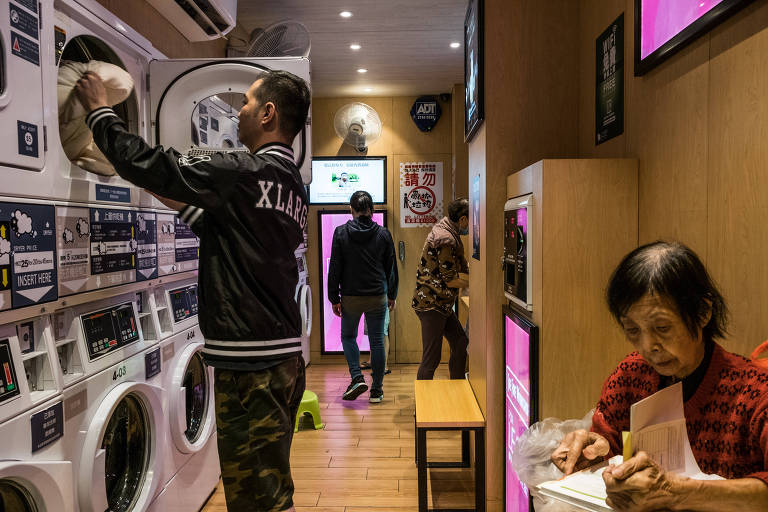 Clientes dentro de uma lavanderia self-service em Hong Kong 