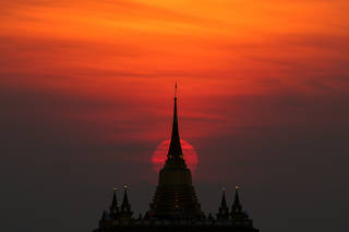 The sun sets behind Wat Saket Temple, or Golden Mount in Bangkok