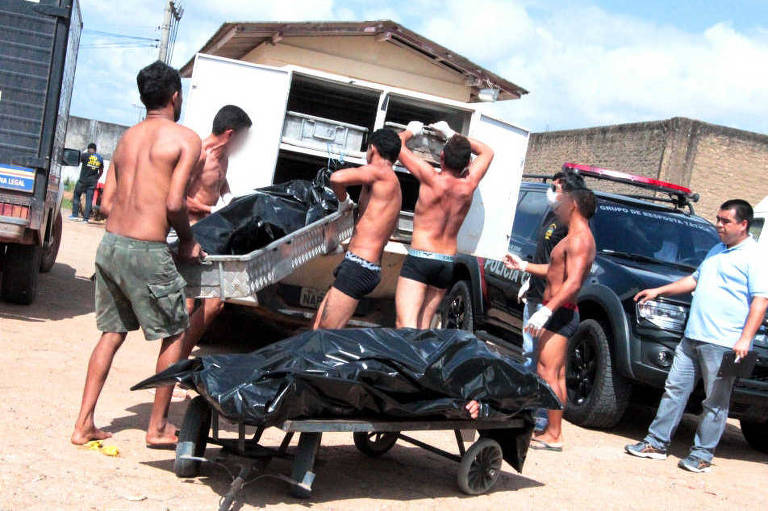 Massacre em Roraima: Presos carregam corpos após rebelião terminar com 33 presos mortos na Penitenciária Agrícola de Monte Cristo, também em janeiro de 2017