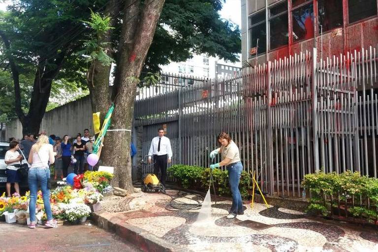 Com bandeiras do Brasil, manifestantes levam flores e limpam prédio de Cármen em BH